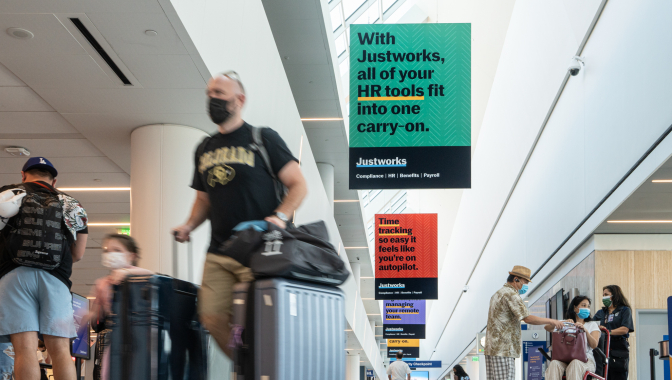 Static hanging banners feature JustWorks advertising at LAX